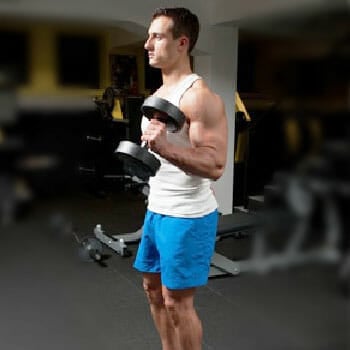 man in the gym in a hammer dumbbell curls position