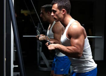 man working out using ropes in a gym