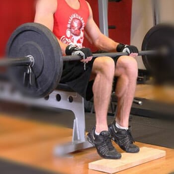 man with a barbell in a calf raise position