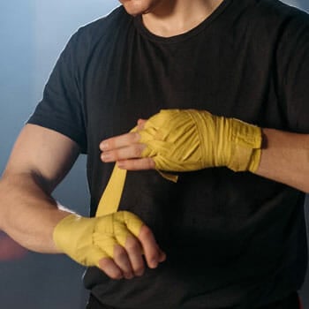 close up image of a man wrapping his hands for boxing