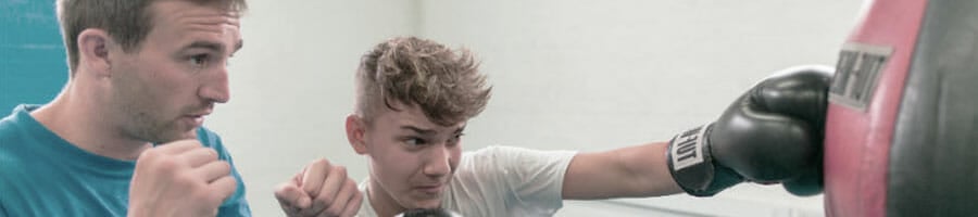 teen learning how to use a speed bag