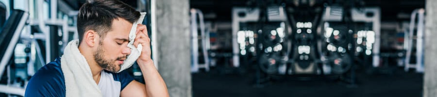 man tired while sitting down in a gym