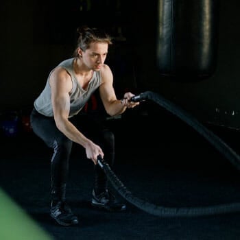 man using ropes inside a gym