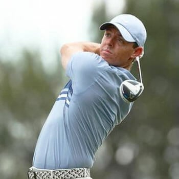 rory mcilroy playing golf with a blue shirt on