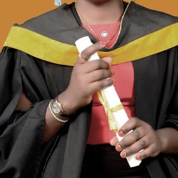 woman in a graduation dress while holding her diploma