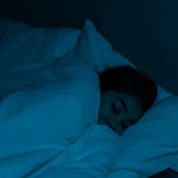 woman resting in her bedroom with lights off