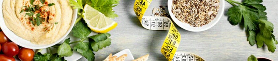 Healthy green foods and a measuring tape