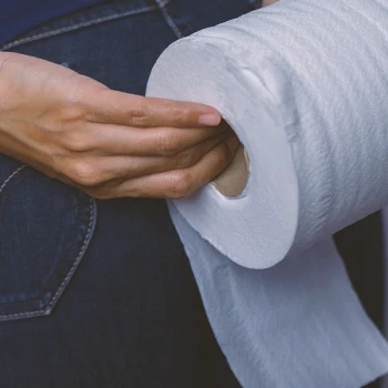 A person holding a tissue roll due to diarrhea