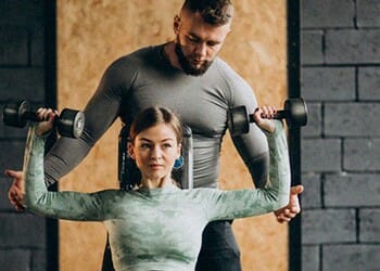 Personal Trainer helping their student to lift