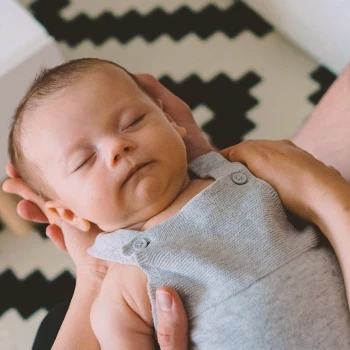 A person holding a sleeping baby