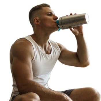 A guy sitting and drinking a creatine supplement drink