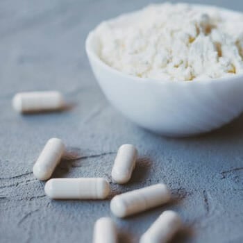 white pills scattered on the table and a powder in a bowl