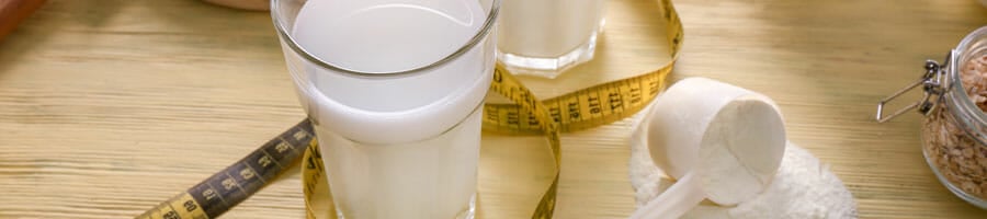 protein shake in a glass with a powder scooper beside