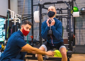 trainer guiding a man in his goblet squats