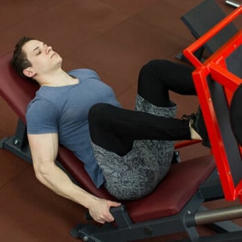 man working out using a leg press machine