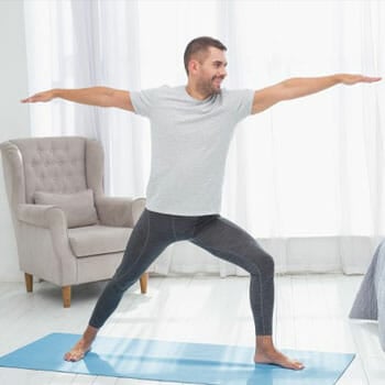 happy man practicing yoga at home