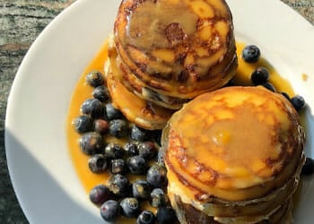 plate filled with pancakes and blueberries