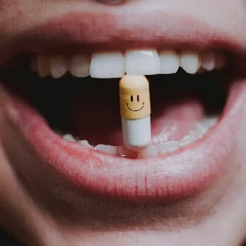 woman holding a pill with her teeth