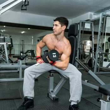 man doing a dumbbell workout in the gym