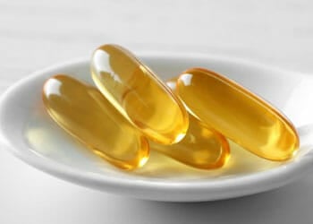 fish oil pills in a white spoon