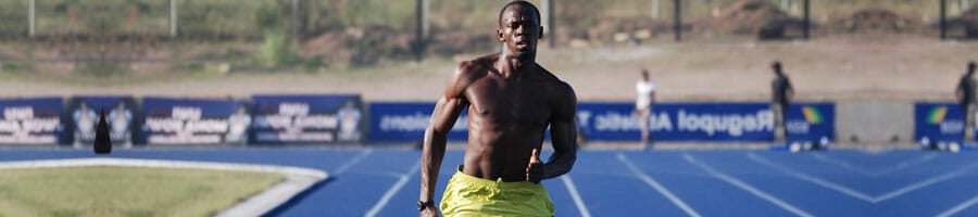 shirtless usain bolt jogging in a field