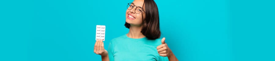 woman holding a sachet of pills with her thumbs up