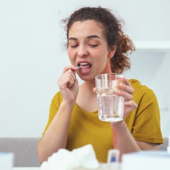 woman about to swallow a supplement