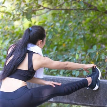 woman stretching out in the park before running