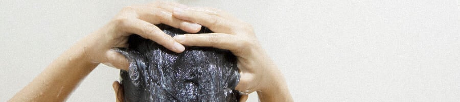 A woman taking a shower cleaning her hair