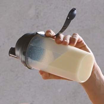 A person holding a bottle containing Creatine