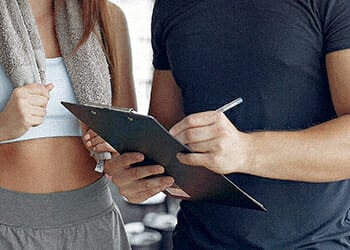 A coach writing down on clipboard at the gym