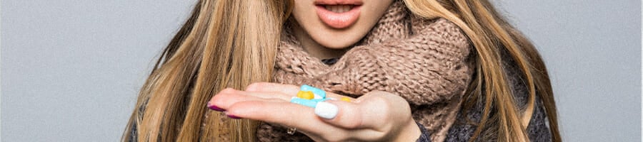 A woman looking at the vitamins on her hand