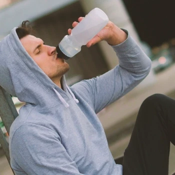 Man drinking water with vitamins after workout