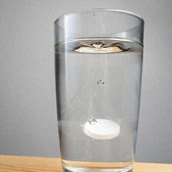 A water soluble vitamin inside a glass of water