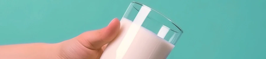 A person holding a glass of milk