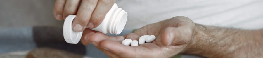 A person pouring vitamins on his hand