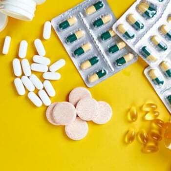 pills and capsules in a yellow background