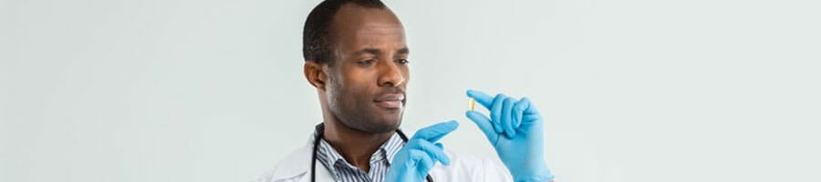 medical personnel looking and holding a pill