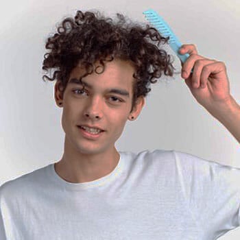 man brushing his curly hair