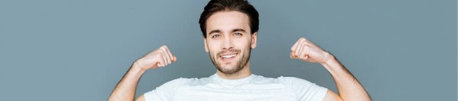 young man smiling with both his arms flexing