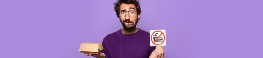 man holding a no buger sign and a take out sandwich