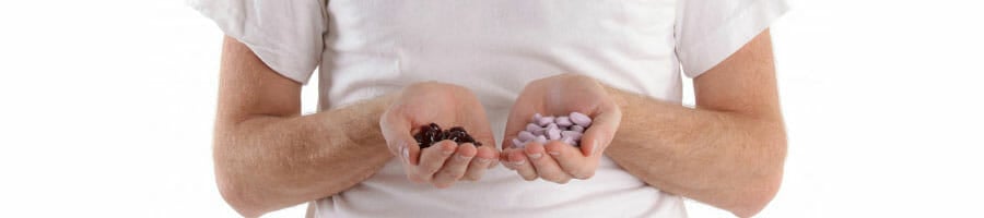 man with two handfuls of pills