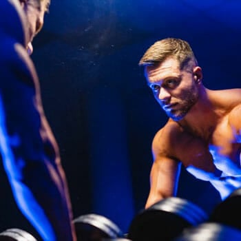 shirtless man leaning on a mirror