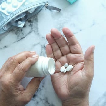 man filling his hands with white pills