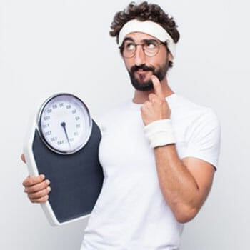 man holding a weighing scale and contemplating