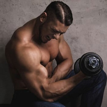 shirtless man working out with a dumbbell