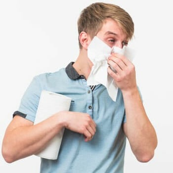 man holding a tissue roll and wiping his runny nose