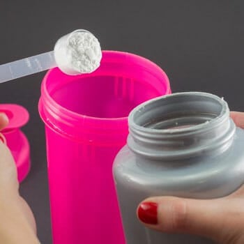 white powder getting scooped from a pink container