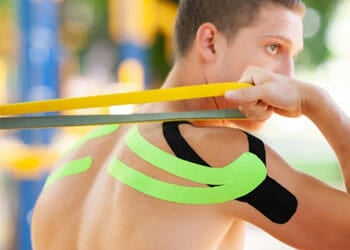 man working out with kinesio tapes on his back