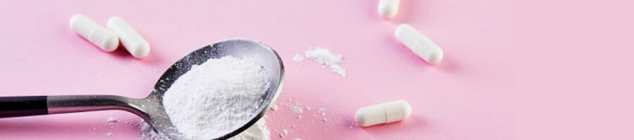 spoon filled with white powder and white pills scattered